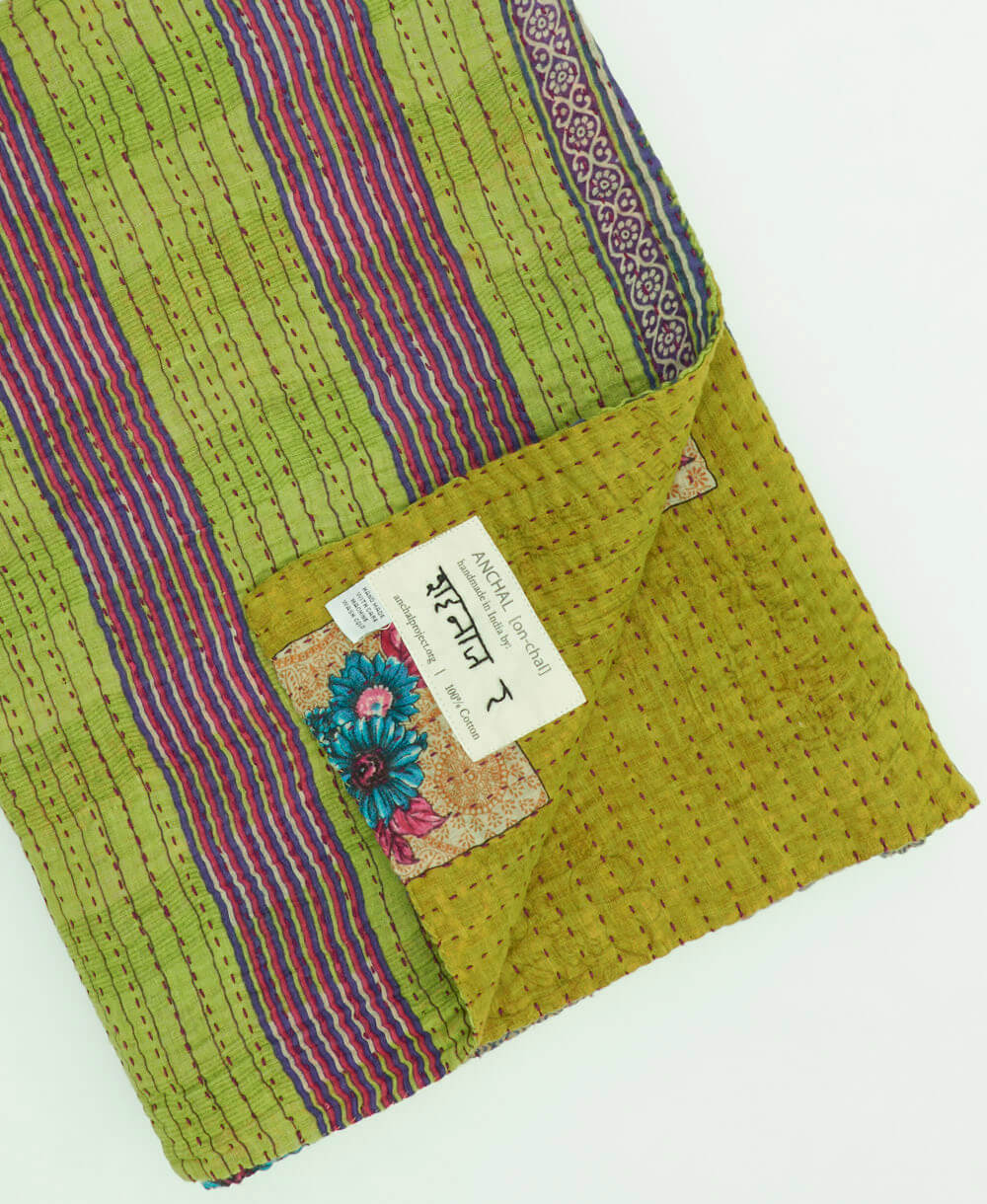 lime & purple stripe kantha quilt throw with a tag featuring the hand-stitched signature of the maker