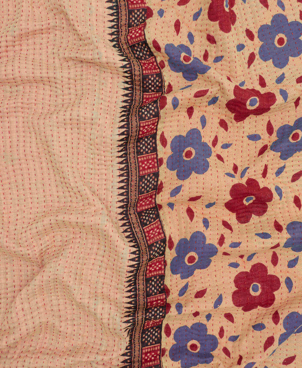 red & purple daisy kantha quilt throw with a tag featuring the hand-stitched signature of the maker