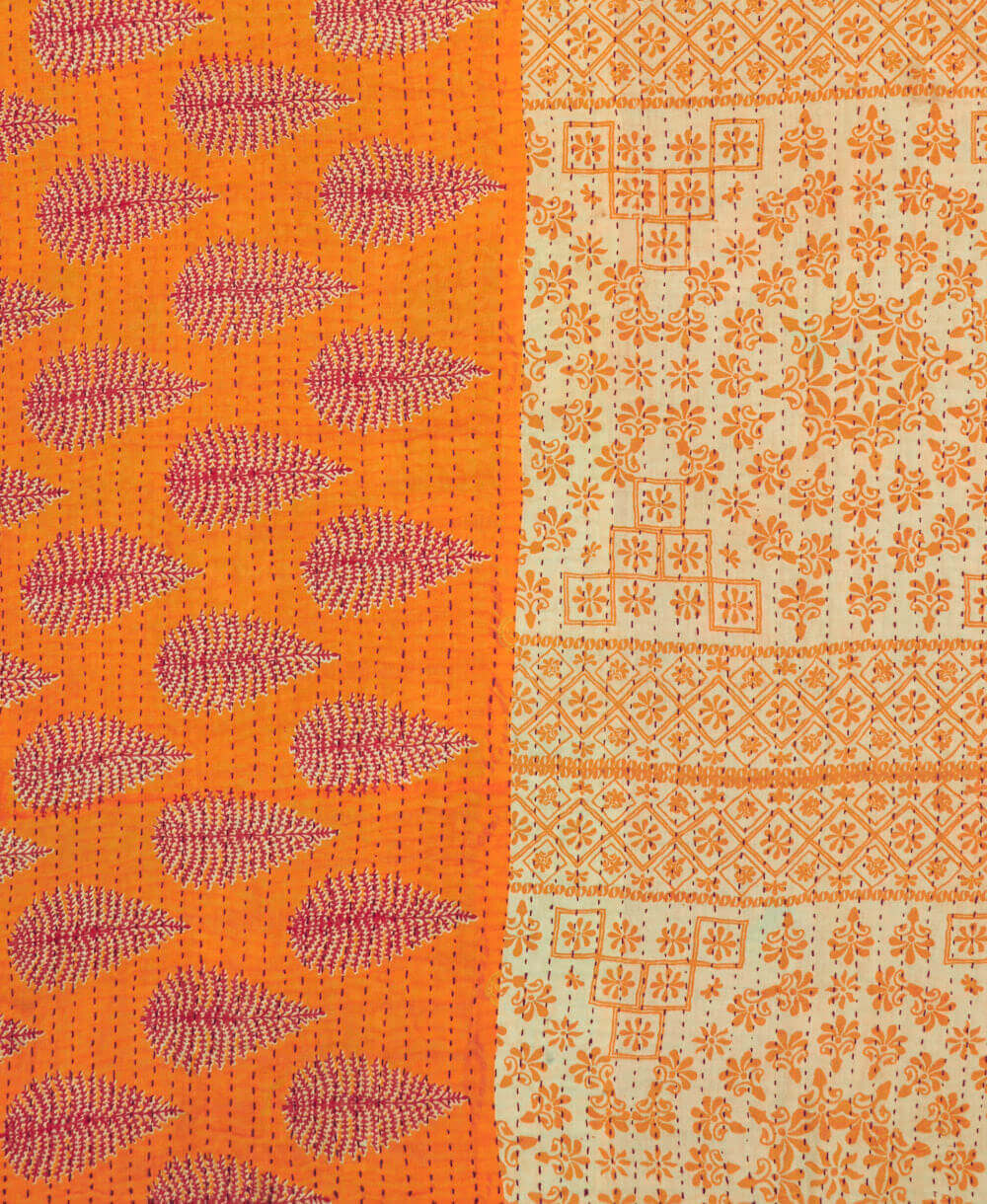 Kantha quilt throw featuring orange & red leaf  print & red kantha hand stitching