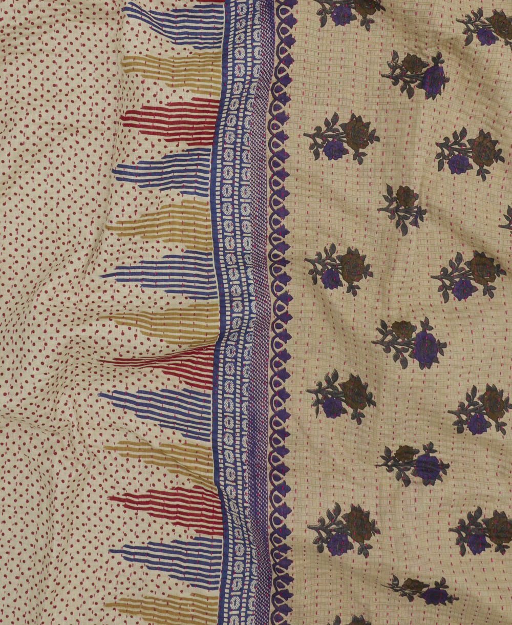 sandy tan kantha quilt throw with a tag featuring the hand-stitched signature of the maker