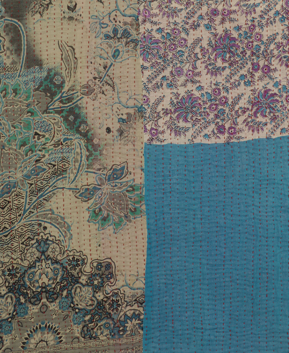 stormy blue kantha quilt throw with a tag featuring the hand-stitched signature of the maker