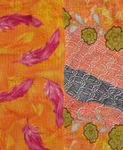 bright orange kantha quilt throw with a tag featuring the hand-stitched signature of the maker