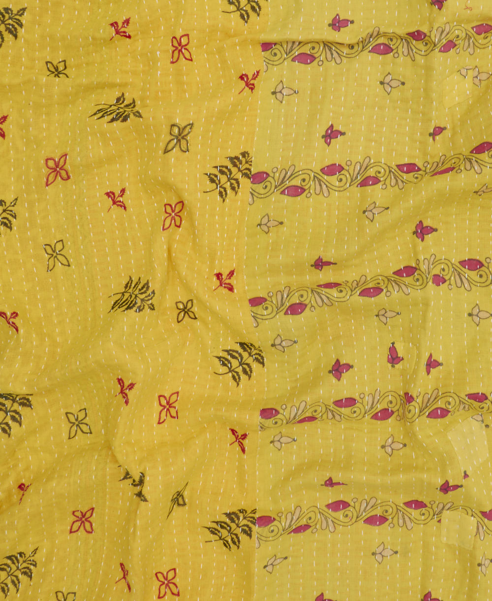 bright yellow & pink kantha quilt throw with a tag featuring the hand-stitched signature of the maker