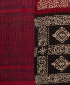 cranberry red kantha quilt throw with a tag featuring the hand-stitched signature of the maker