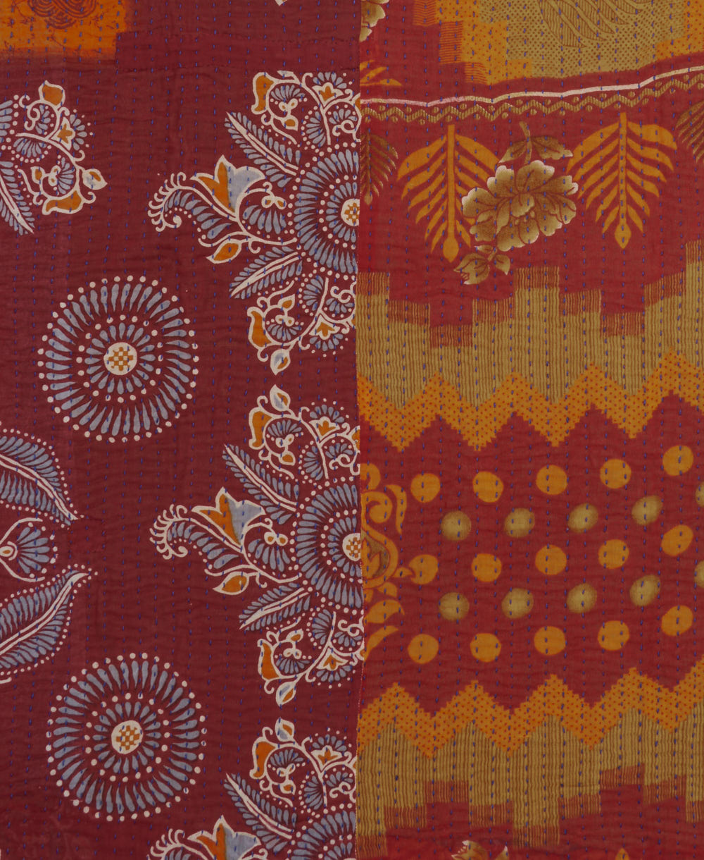 orange & red kantha quilt throw with a tag featuring the hand-stitched signature of the maker