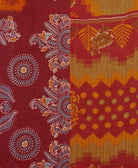 orange & red kantha quilt throw with a tag featuring the hand-stitched signature of the maker