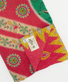 hot pink & yellow chevron kantha quilt throw with a tag featuring the hand-stitched signature of the maker