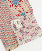 kantha quilt throw with a tag featuring the hand-stitched signature of the maker