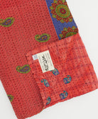 kantha quilt throw with a tag featuring the hand-stitched signature of the maker