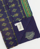kantha quilt throw with a tag featuring the hand-stitched signature of the maker