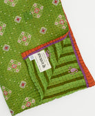 kantha quilt throw with a tag featuring the hand-stitched signature of the maker