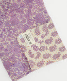 kantha quilt throw with a tag featuring the hand-stitched signature of the maker