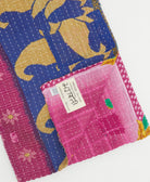 kantha quilt throw with a tag featuring the hand-stitched signature of the maker