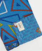 kantha quilt throw with a tag featuring the hand-stitched signature of the maker