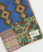 kantha quilt throw with a tag featuring the hand-stitched signature of the maker