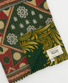 kantha quilt throw with a tag featuring the hand-stitched signature of the maker