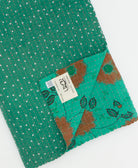 kantha quilt throw with a tag featuring the hand-stitched signature of the maker