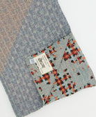 kantha quilt throw with a tag featuring the hand-stitched signature of the maker