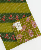 kantha quilt throw with a tag featuring the hand-stitched signature of the maker