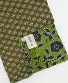 kantha quilt throw with a tag featuring the hand-stitched signature of the maker