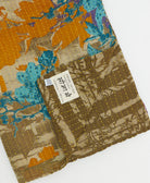 kantha quilt throw with a tag featuring the hand-stitched signature of the maker