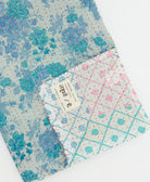 kantha quilt throw with a tag featuring the hand-stitched signature of the maker