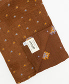 kantha quilt throw with a tag featuring the hand-stitched signature of the maker