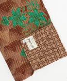 kantha quilt throw with a tag featuring the hand-stitched signature of the maker