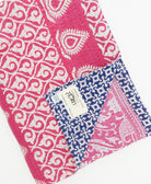 kantha quilt throw with a tag featuring the hand-stitched signature of the maker
