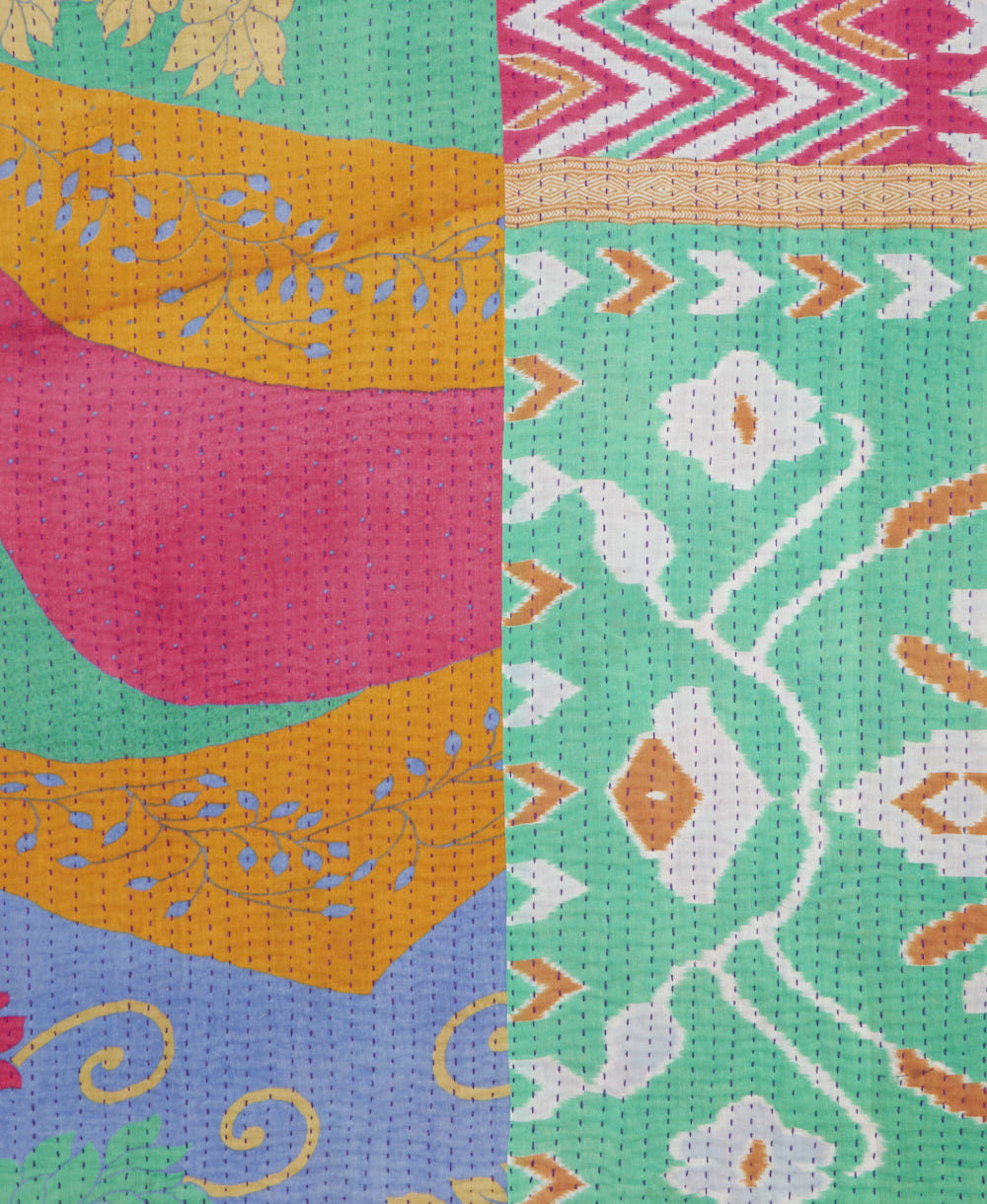kantha quilt throw with a tag featuring the hand-stitched signature of the maker