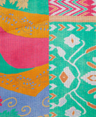 kantha quilt throw with a tag featuring the hand-stitched signature of the maker