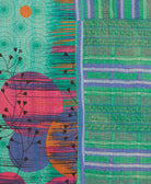 kantha quilt throw with a tag featuring the hand-stitched signature of the maker