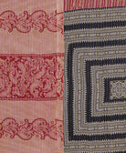 kantha quilt throw with a tag featuring the hand-stitched signature of the maker