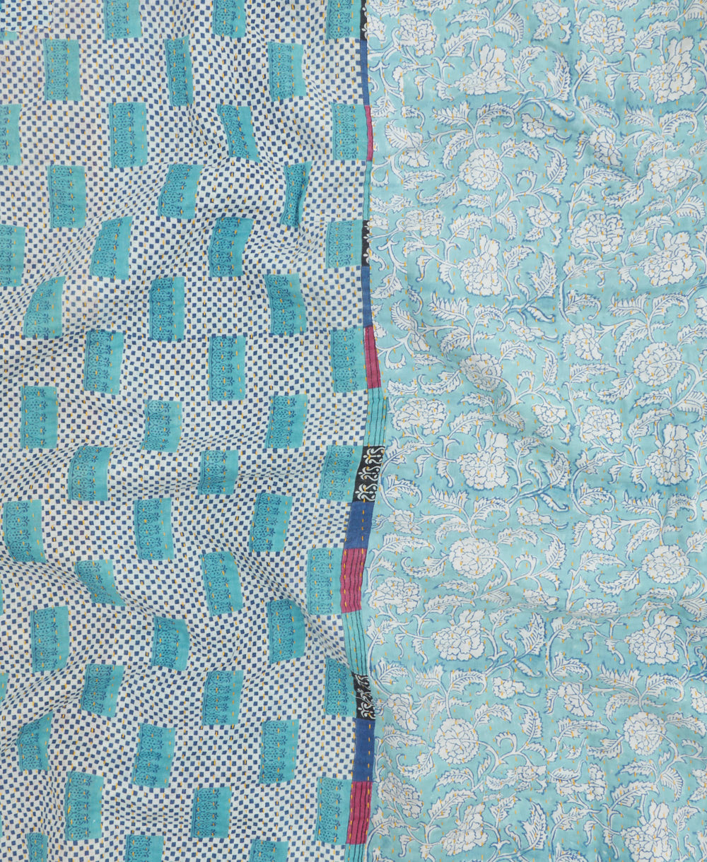 kantha quilt throw with a tag featuring the hand-stitched signature of the maker