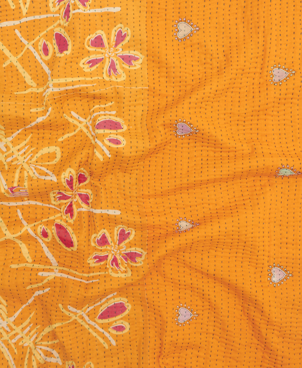 kantha quilt throw with a tag featuring the hand-stitched signature of the maker