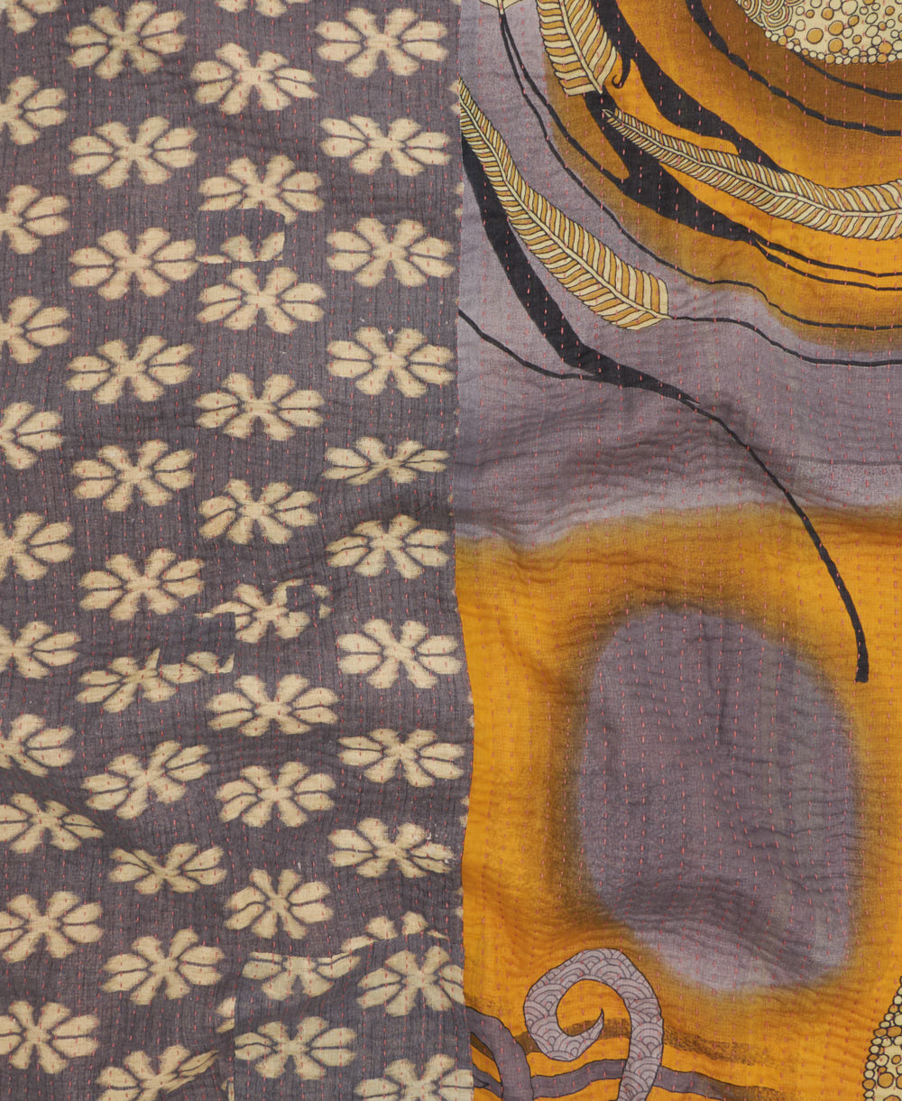 kantha quilt throw with a tag featuring the hand-stitched signature of the maker