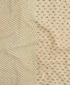 kantha quilt throw with a tag featuring the hand-stitched signature of the maker