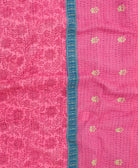 kantha quilt throw with a tag featuring the hand-stitched signature of the maker