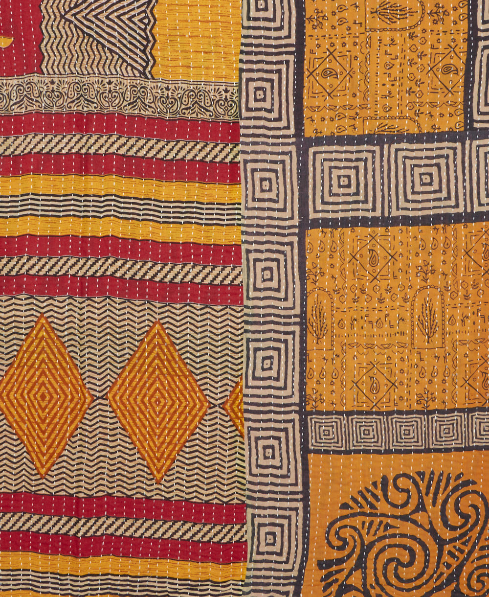 kantha quilt throw with a tag featuring the hand-stitched signature of the maker