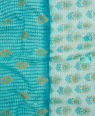 kantha quilt throw with a tag featuring the hand-stitched signature of the maker