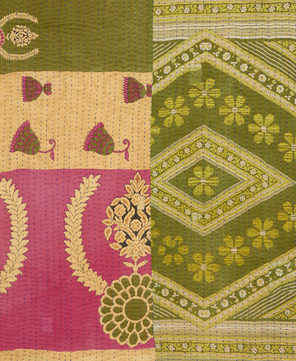 kantha quilt throw with a tag featuring the hand-stitched signature of the maker