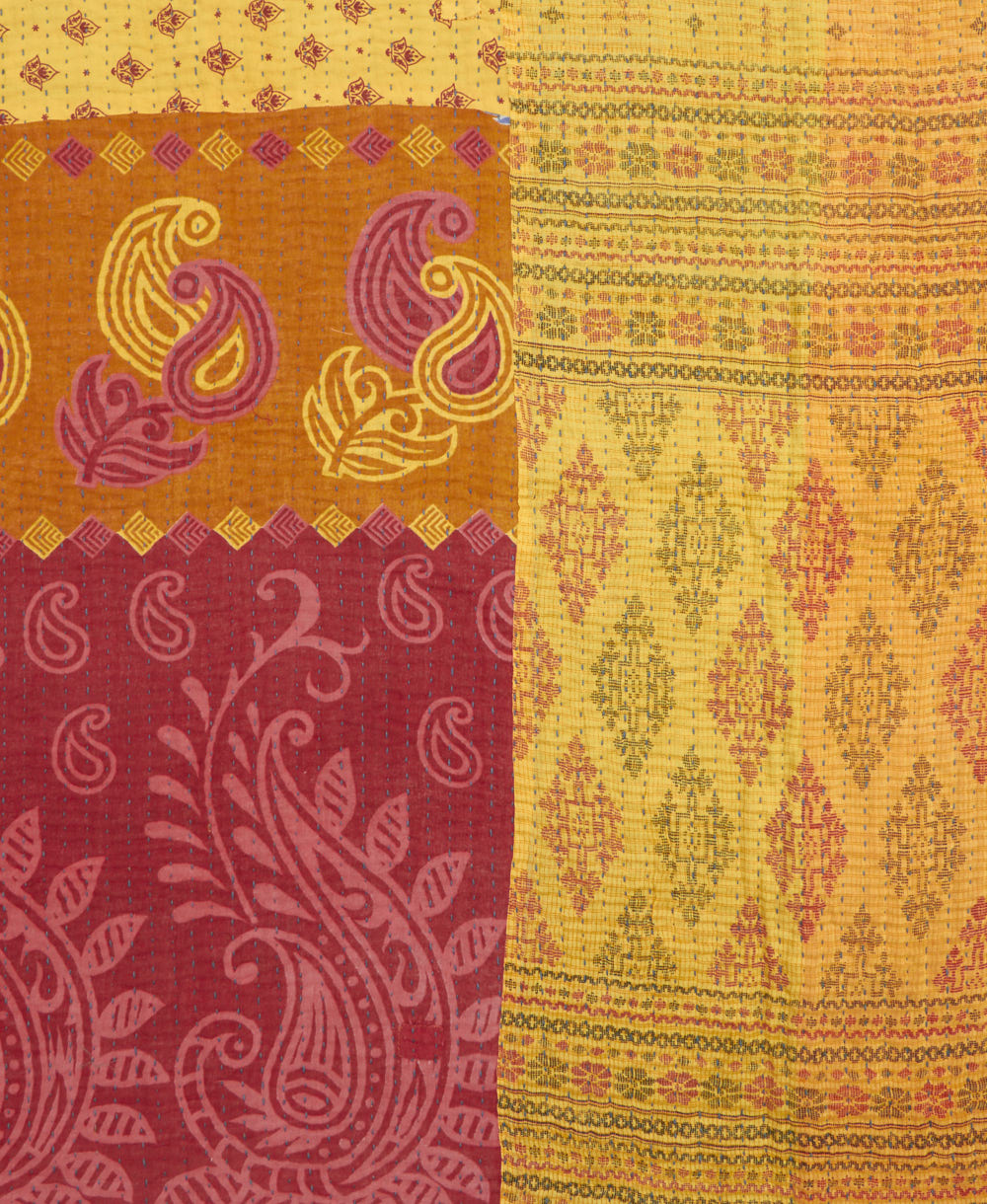 kantha quilt throw with a tag featuring the hand-stitched signature of the maker