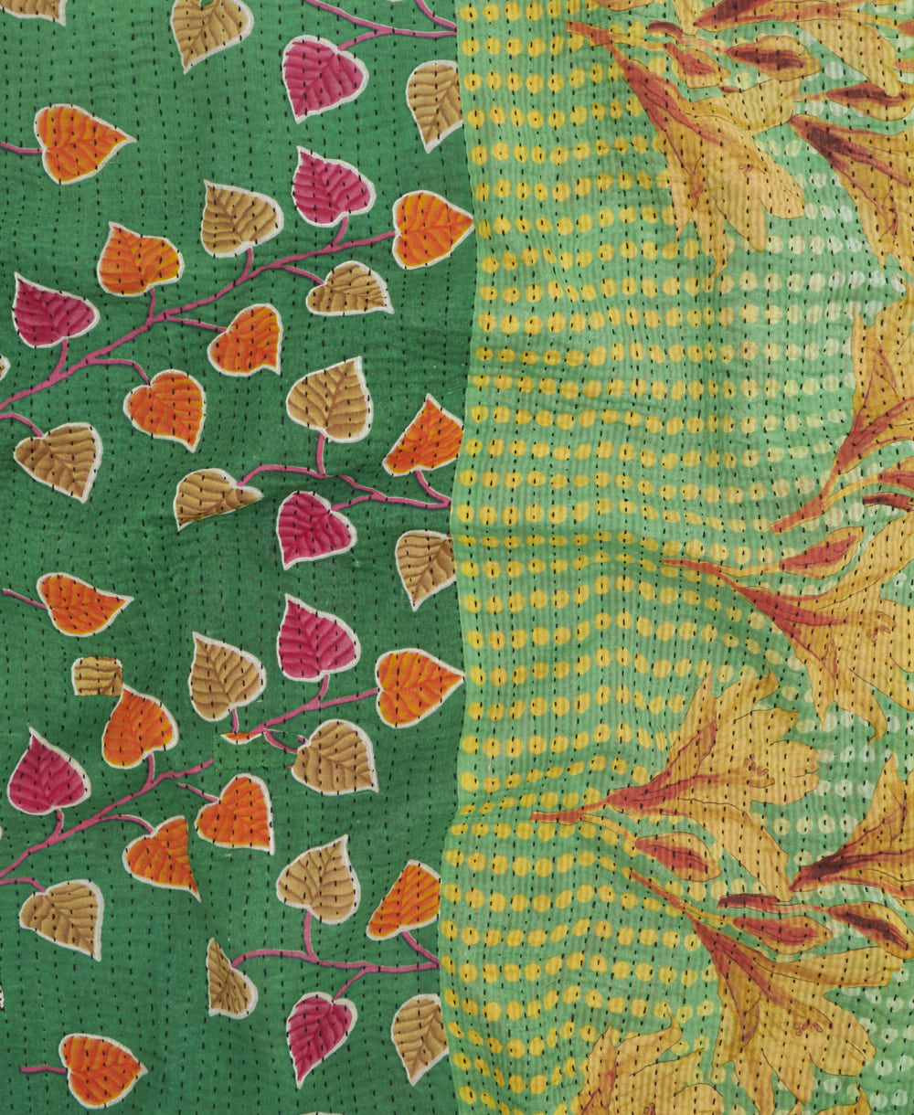 kantha quilt throw with a tag featuring the hand-stitched signature of the maker