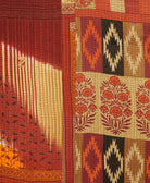 kantha quilt throw with a tag featuring the hand-stitched signature of the maker