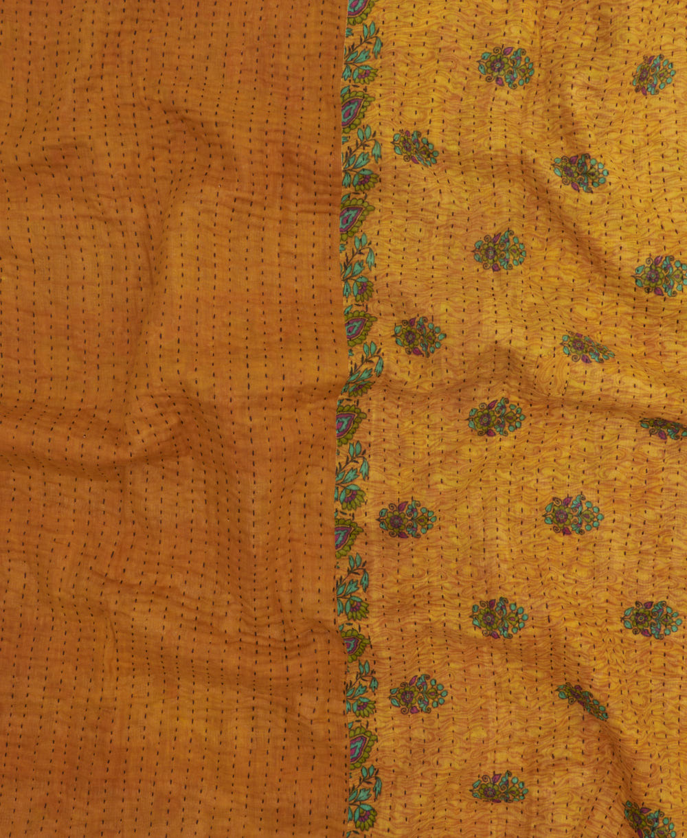 kantha quilt throw with a tag featuring the hand-stitched signature of the maker