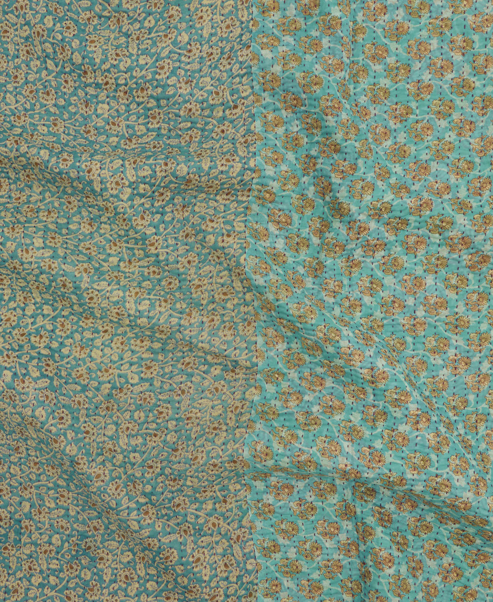 kantha quilt throw with a tag featuring the hand-stitched signature of the maker