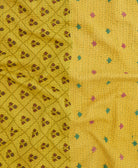 kantha quilt throw with a tag featuring the hand-stitched signature of the maker