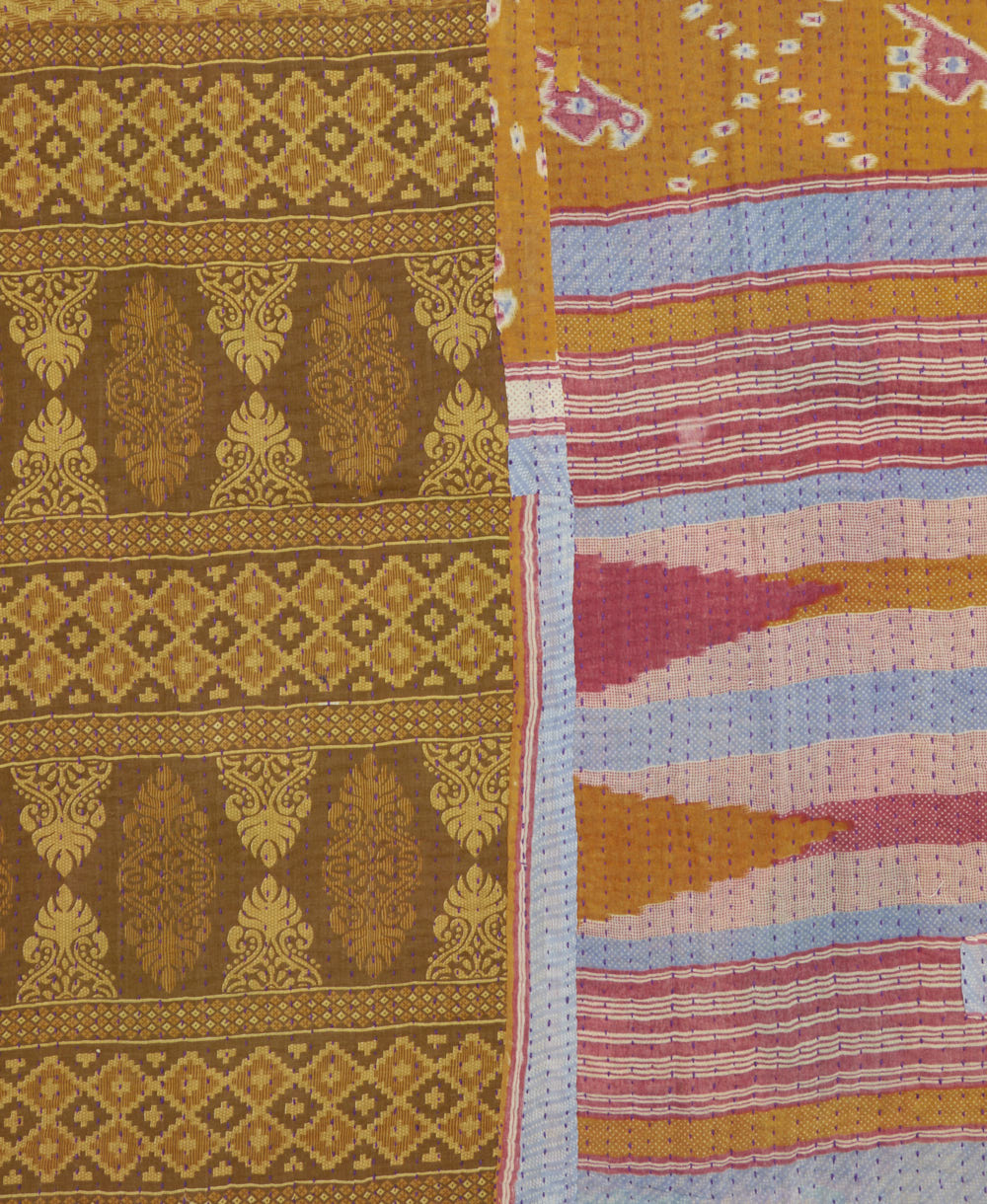 kantha quilt throw with a tag featuring the hand-stitched signature of the maker