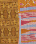 kantha quilt throw with a tag featuring the hand-stitched signature of the maker