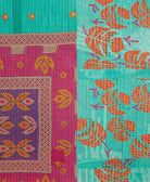 kantha quilt throw with a tag featuring the hand-stitched signature of the maker